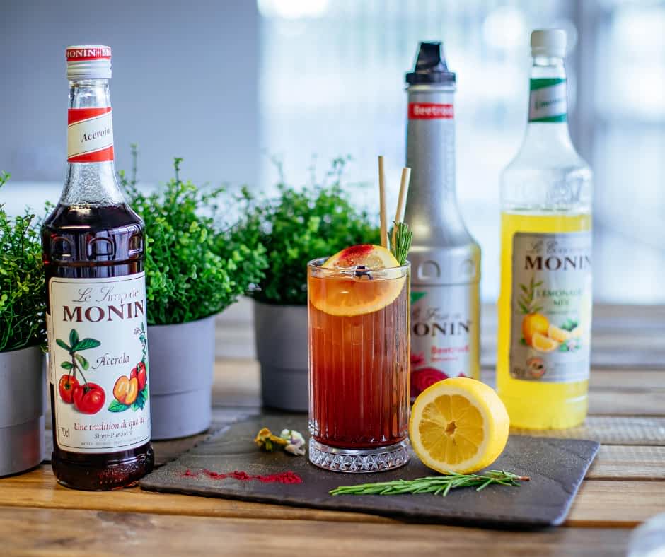 A range of Monin Syrups bottles with a cocktail